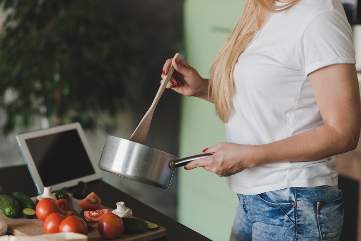 Una donna con una pentola in mano in cucina