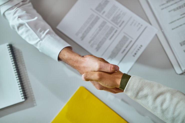 Due persone si stringono la mano a lavoro