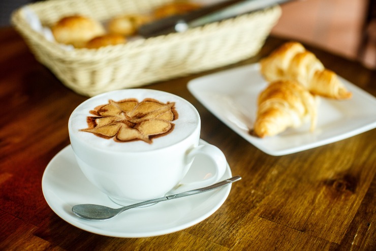 Cornetto e cappuccino su un tavolo
