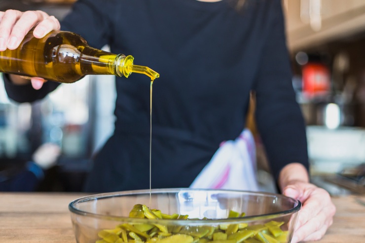 Una persona versa dell'olio nell'insalata