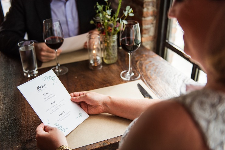 Una persona guarda il menu di un ristorante