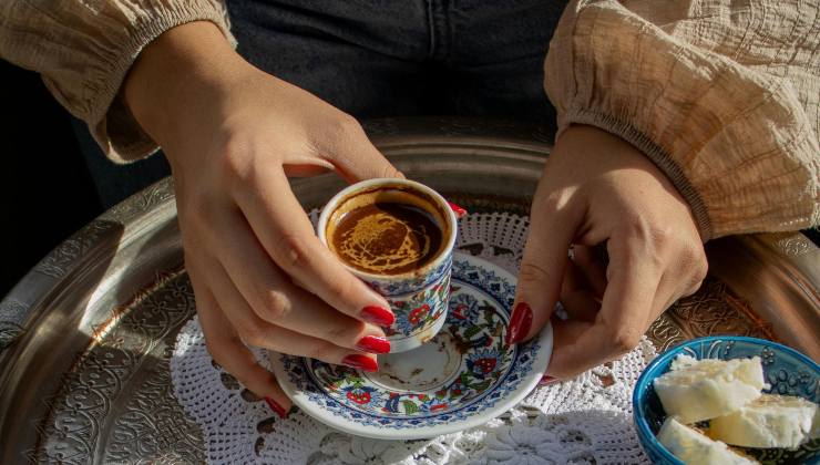 mani femminili con tazzina di caffè