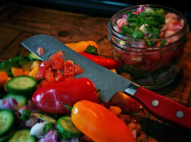 verdure tagliate, coltello e barattolo in vetro