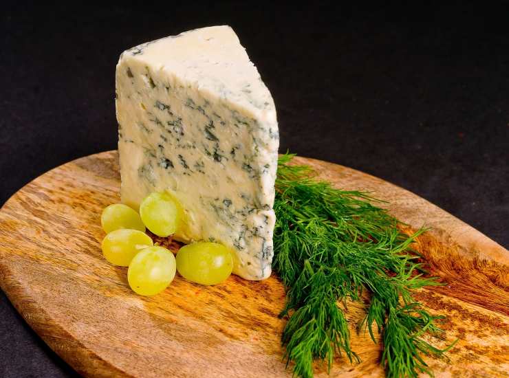 fetta di gorgonzola su tagliere con uva 