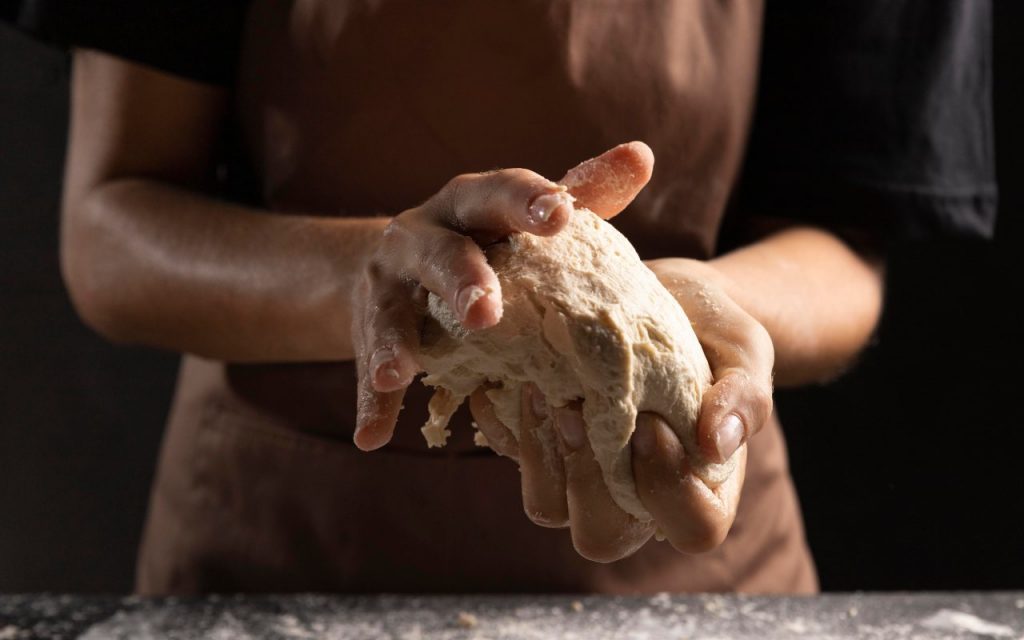 Una persona prepara l'impasto della piadina e del crescione
