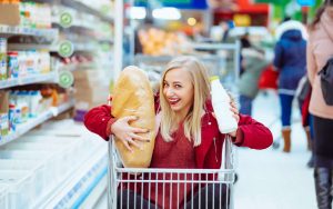 Una ragazza felice al supermercato nel carrello della spesa