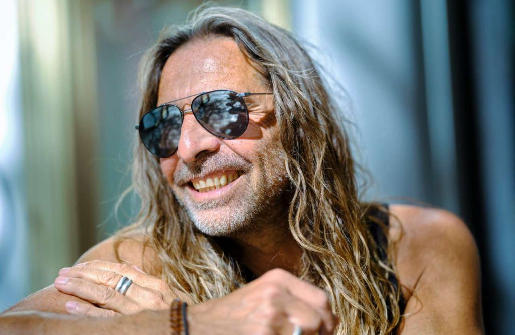 uomo con barba capelli lunghi e occhiali da sole
