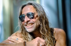 uomo con barba capelli lunghi e occhiali da sole