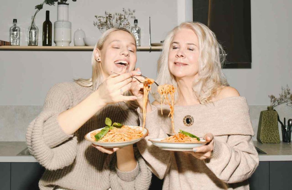 due donne che mangiano spaghetti