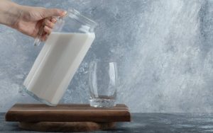 Una persona versa del latte da una caraffa