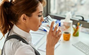 Una persona beve un bicchiere di acqua