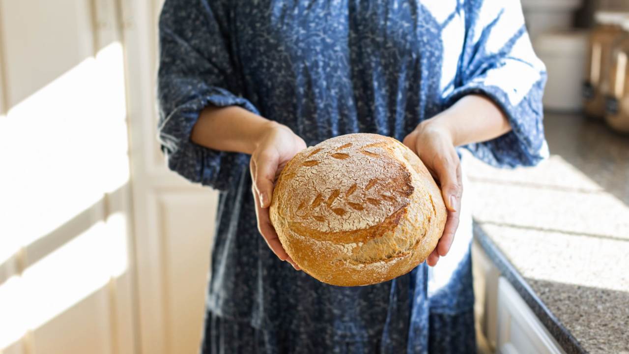 donna che tiene una pagnotta in mano
